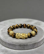 Golden tiger eye Pixiu wealth bracelet Feng Shui abundance courage jewelry — stack styling shot | BuddhaManifest™